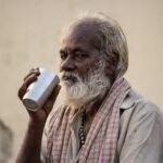 Une personne buvant un verre d'eau le matin, symbolisant le rituel matinal discuté dans l'article.