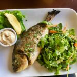 Poisson populaire sur un plat, soulignant son impact négatif sur le cholestérol.