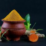 Image de curcuma en poudre avec des racines fraîches, symbolisant ses bienfaits pour la santé.